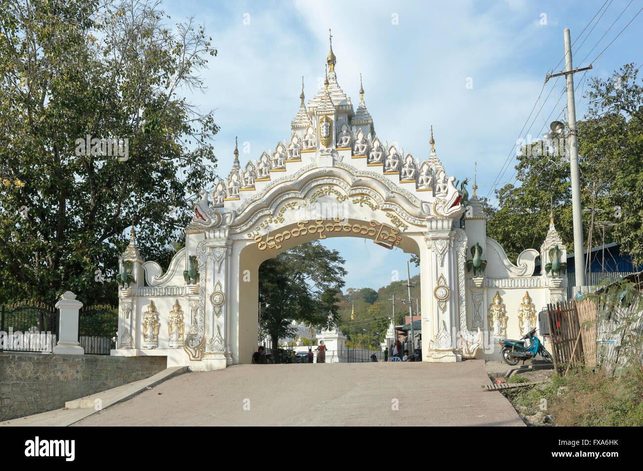 Tipicamente ornato cancello di ingresso alla Kyauk Taw Gyi Pagoda ai piedi del Mandalay Hill, Mandalay Myanmar (Birmania) in una giornata di sole con cielo blu Foto Stock