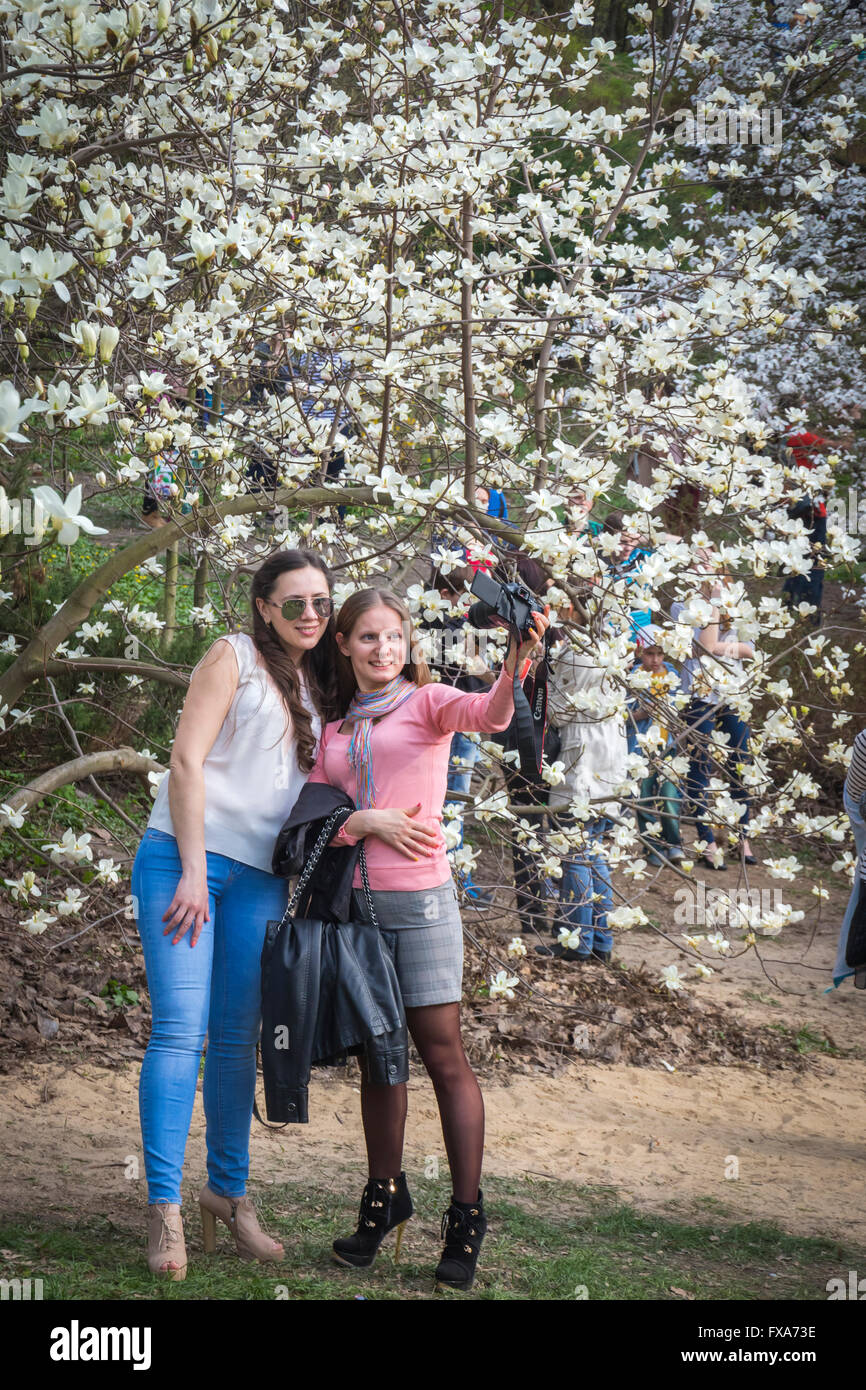 Le persone godono di primavera magnolia fiorisce nel giardino botanico a Kiev, Ucraina Foto Stock