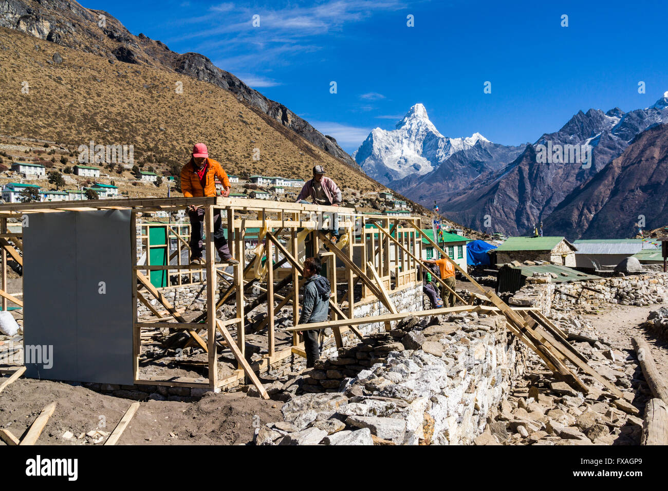 La ricostruzione delle case distrutte dal terremoto del 2015, Ama Dablam (6856m) montagna in distanza, Khumjung Foto Stock
