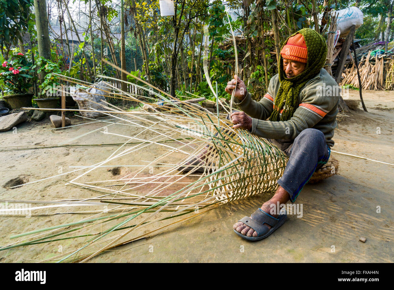 Un uomo è la tessitura di un cesto di bambù, Sauraha, Chitwan, Nepal Foto Stock