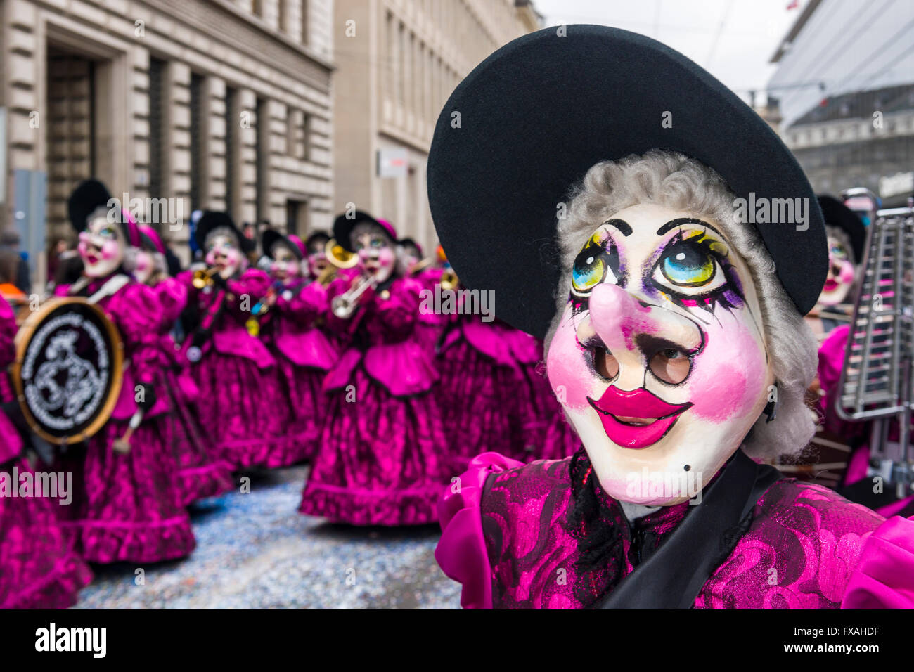 Membri della Gugge Marching Band di ottone che indossa abiti a fantasia e le maschere per la grande processione al Carnevale di Basilea Foto Stock