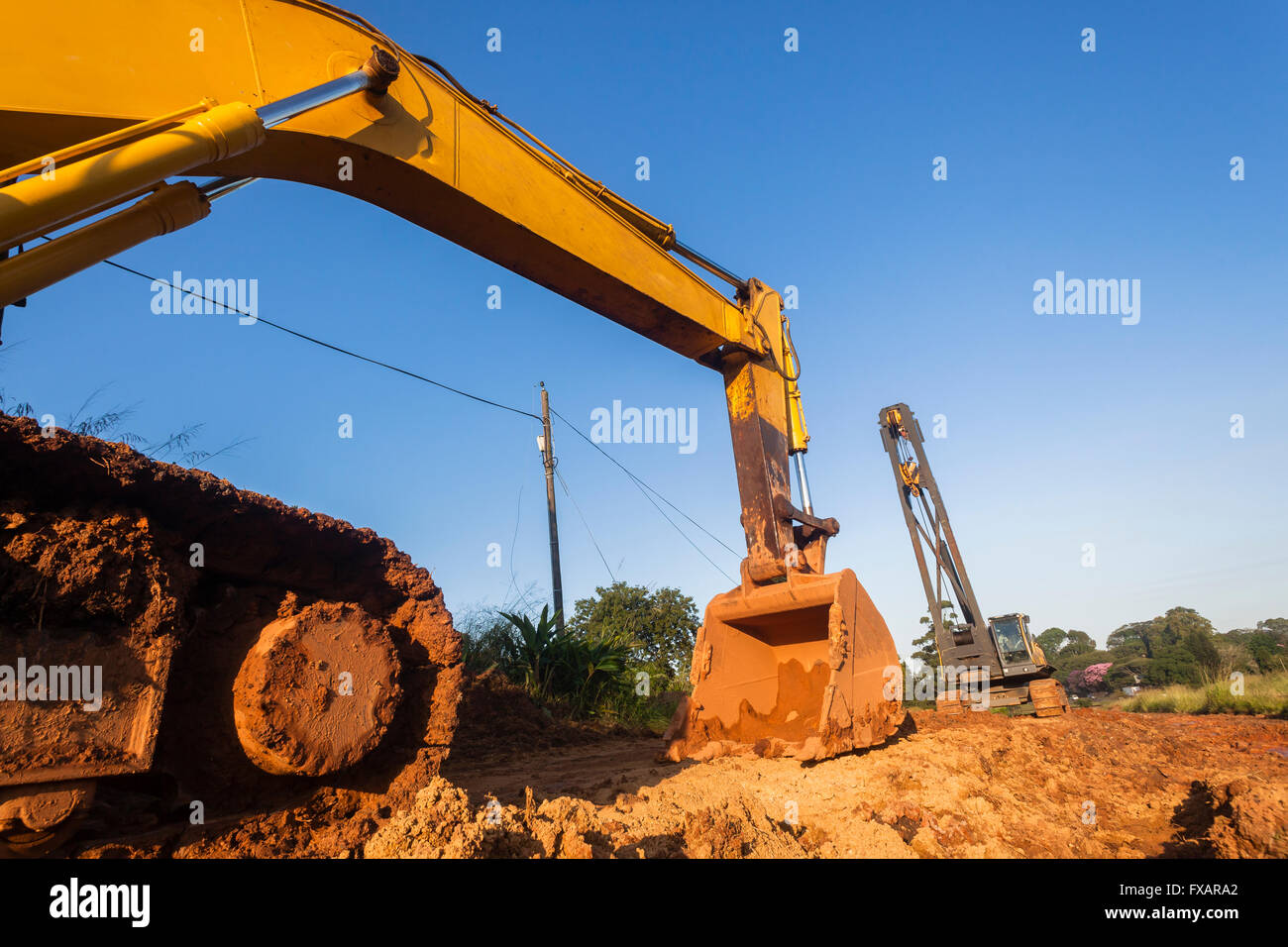 Lavori di sterramento costruzione pesante macchina escavatore bin e mobile gru rigging sul sito Foto Stock