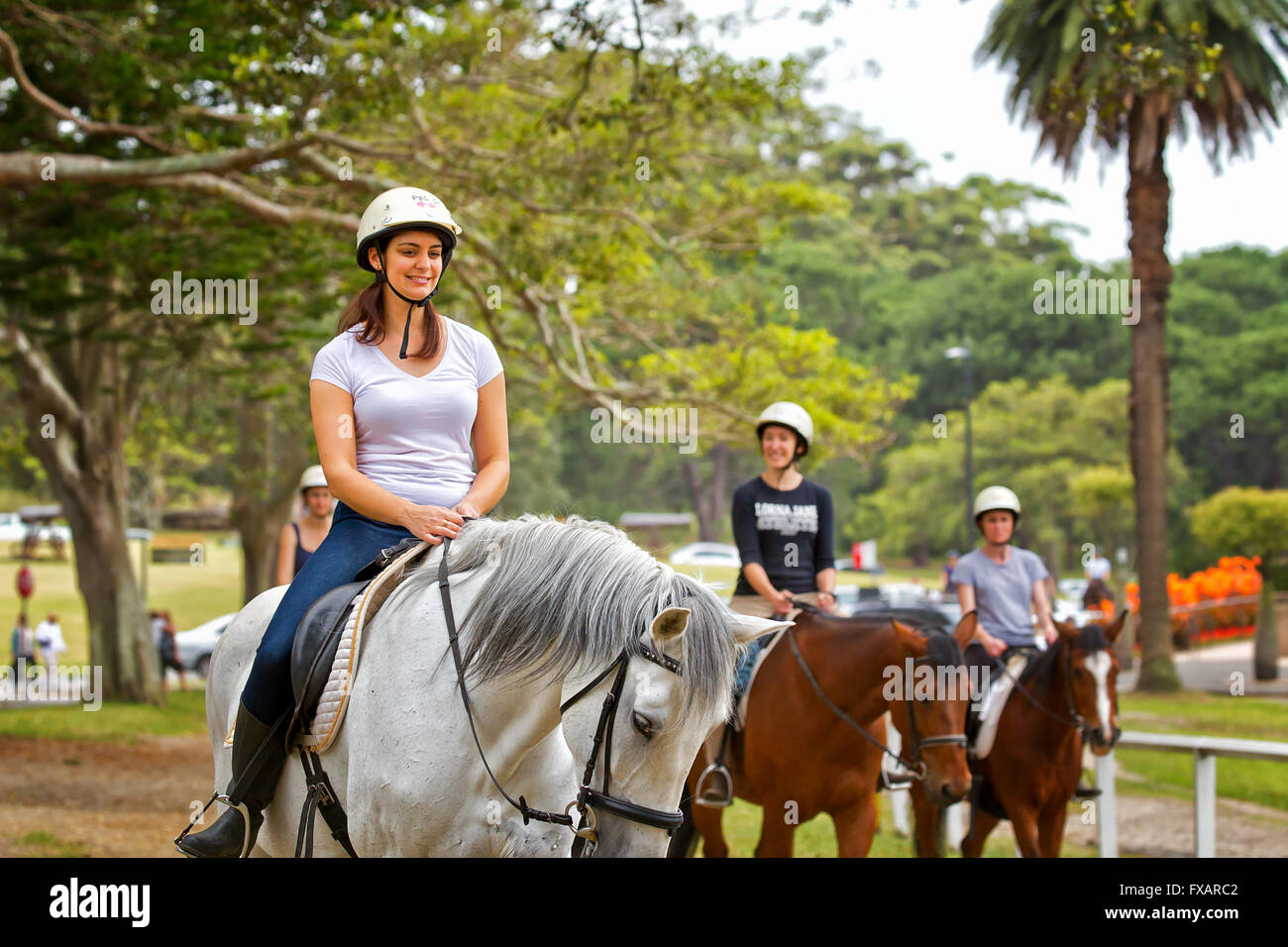 Piuttosto giovani donne corsa dei cavalli attraverso il Centennial Park., Sydney. Foto Stock