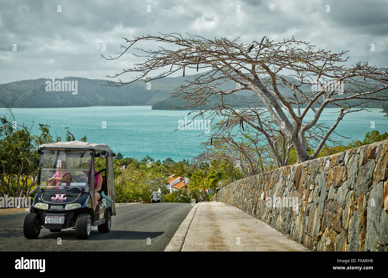 Due donne a guidare una vetturetta da golf alla loro destinazione. Golf buggy e autobus gratuito sono i soli veicoli disponibili qui. Foto Stock