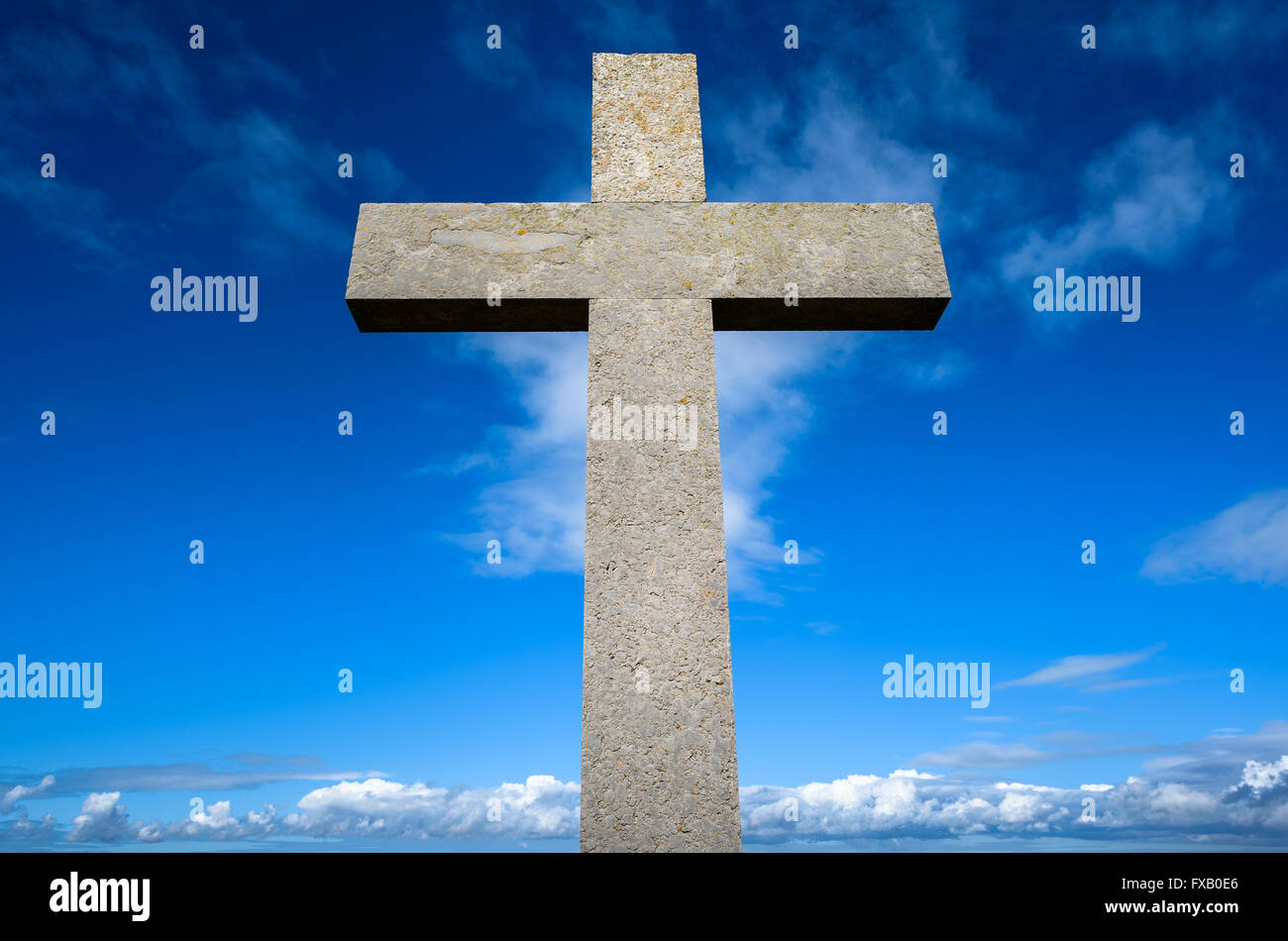 Pietra croce cristiana contro un cielo blu. Foto Stock