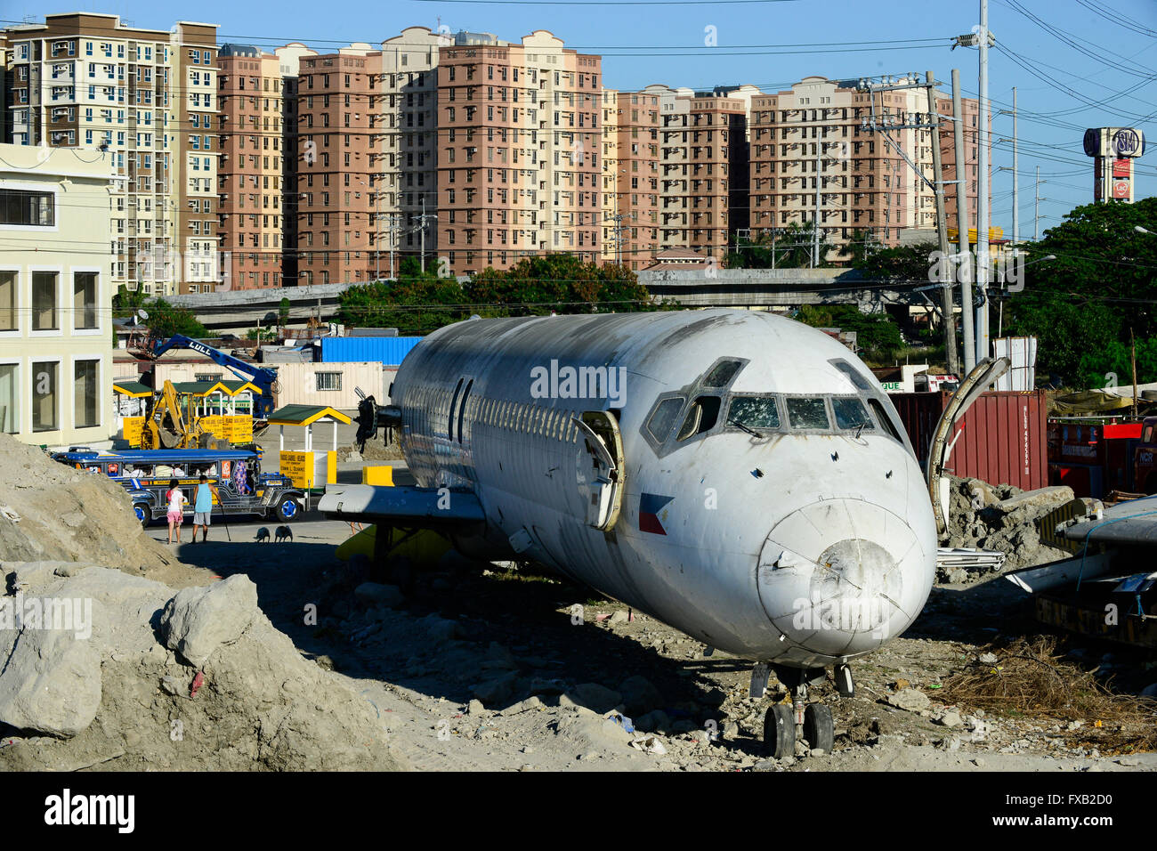 Filippine, Manila, Parañaque City, oggetto di dumping aereo McDonnell Douglas DC-9 della compagnia aerea filippina Cebu Pacific, dietro la torre appartamento Foto Stock
