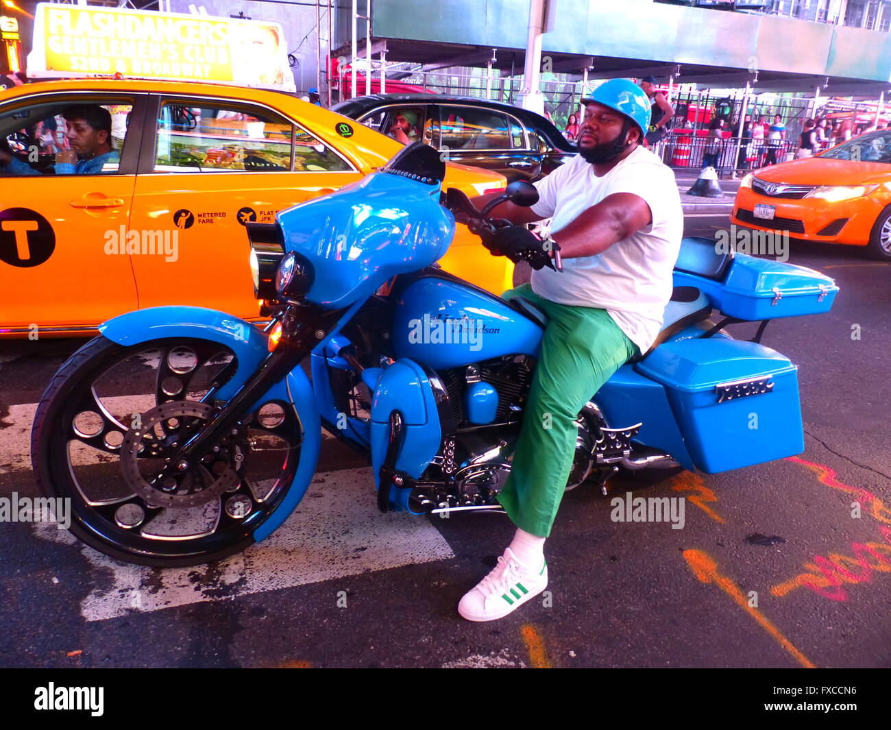 Biker seduto sulla sua Harley mostra off per altri veicoli a Times Square Foto Stock