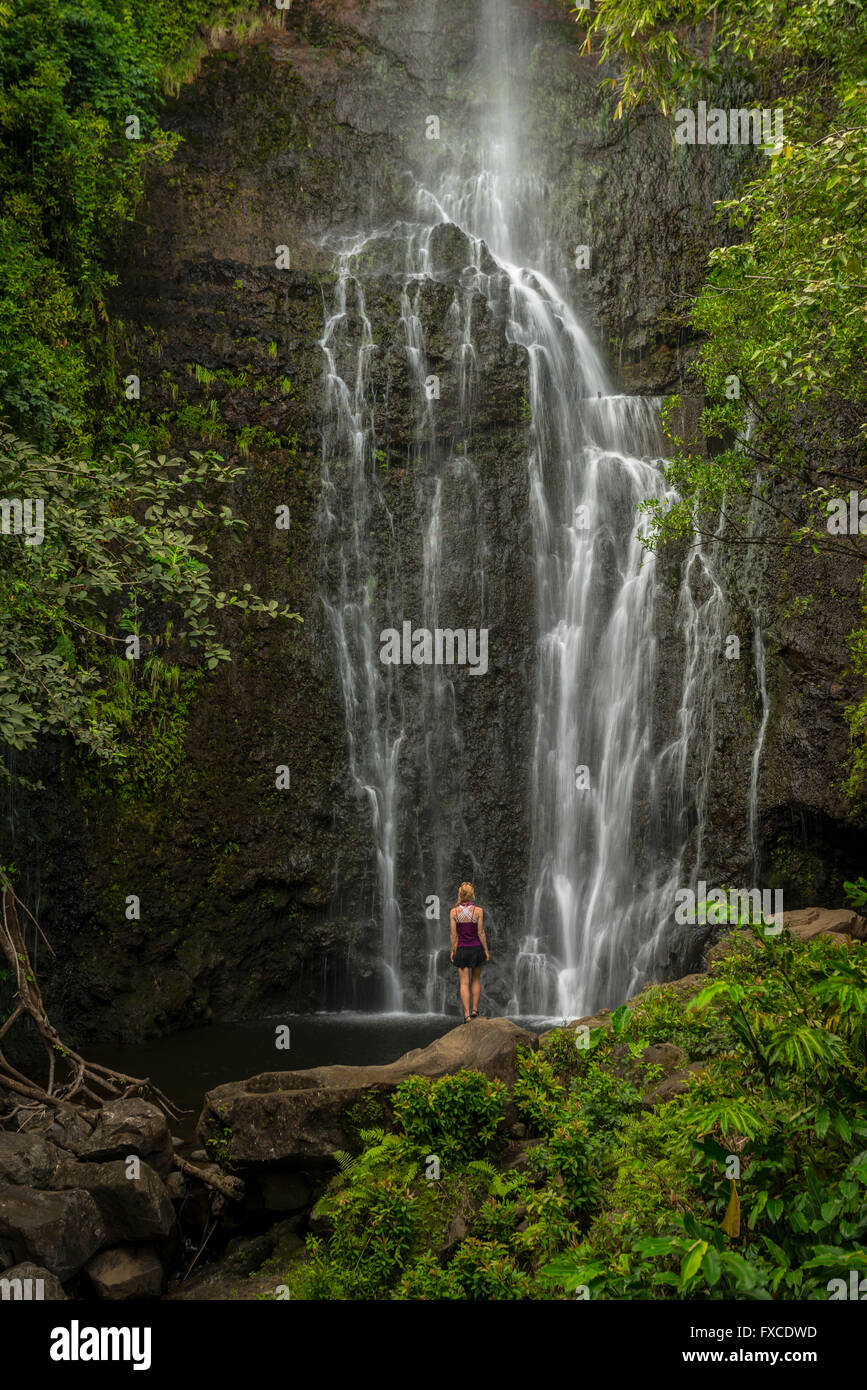 Stati Uniti d'America, Hawaii Maui, Hana, ragazza in piedi di fronte a cascata Foto Stock