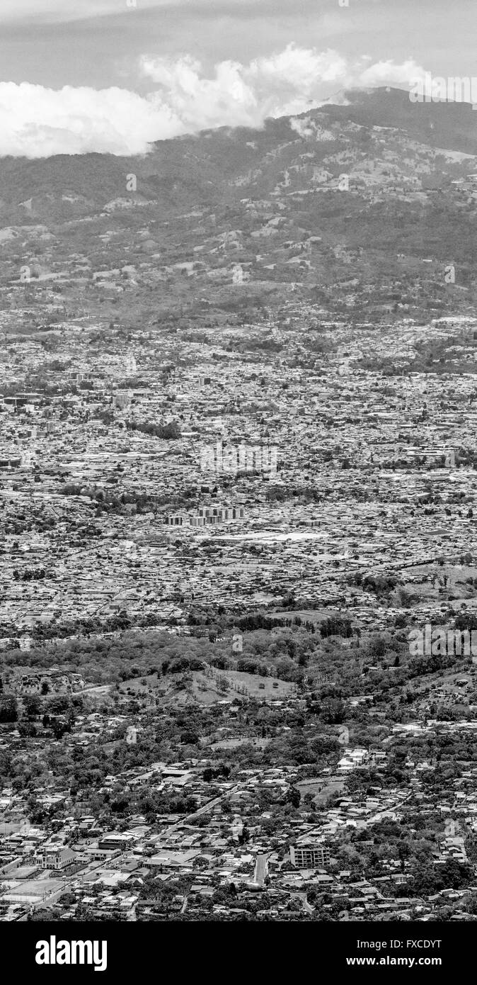 BW versione di vista della città di San Jose, Costa Rica e i segni della deforestazione contro lo sviluppo umano Foto Stock