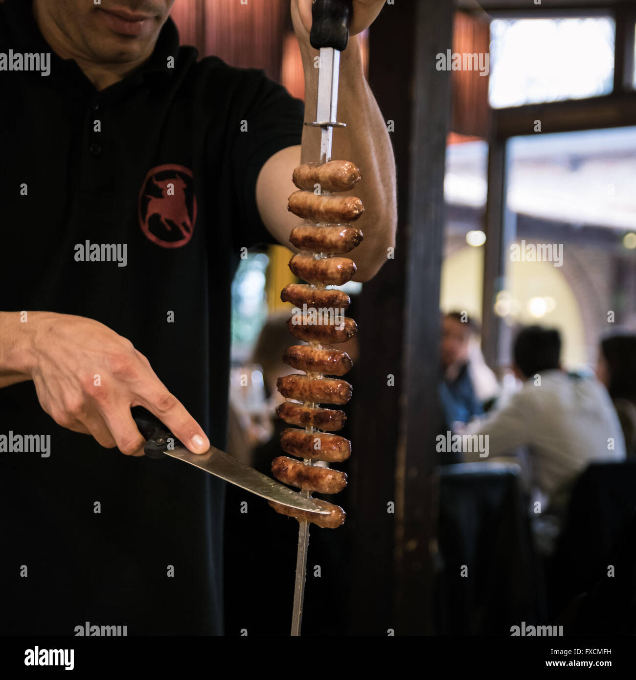 Spiedini di carne allo spiedo servita al tavolo di un ristorante brasiliano. Foto Stock
