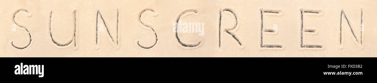 Sunscreen lettering disegnato sulla sabbia. Estate spiaggia sfondo Foto Stock