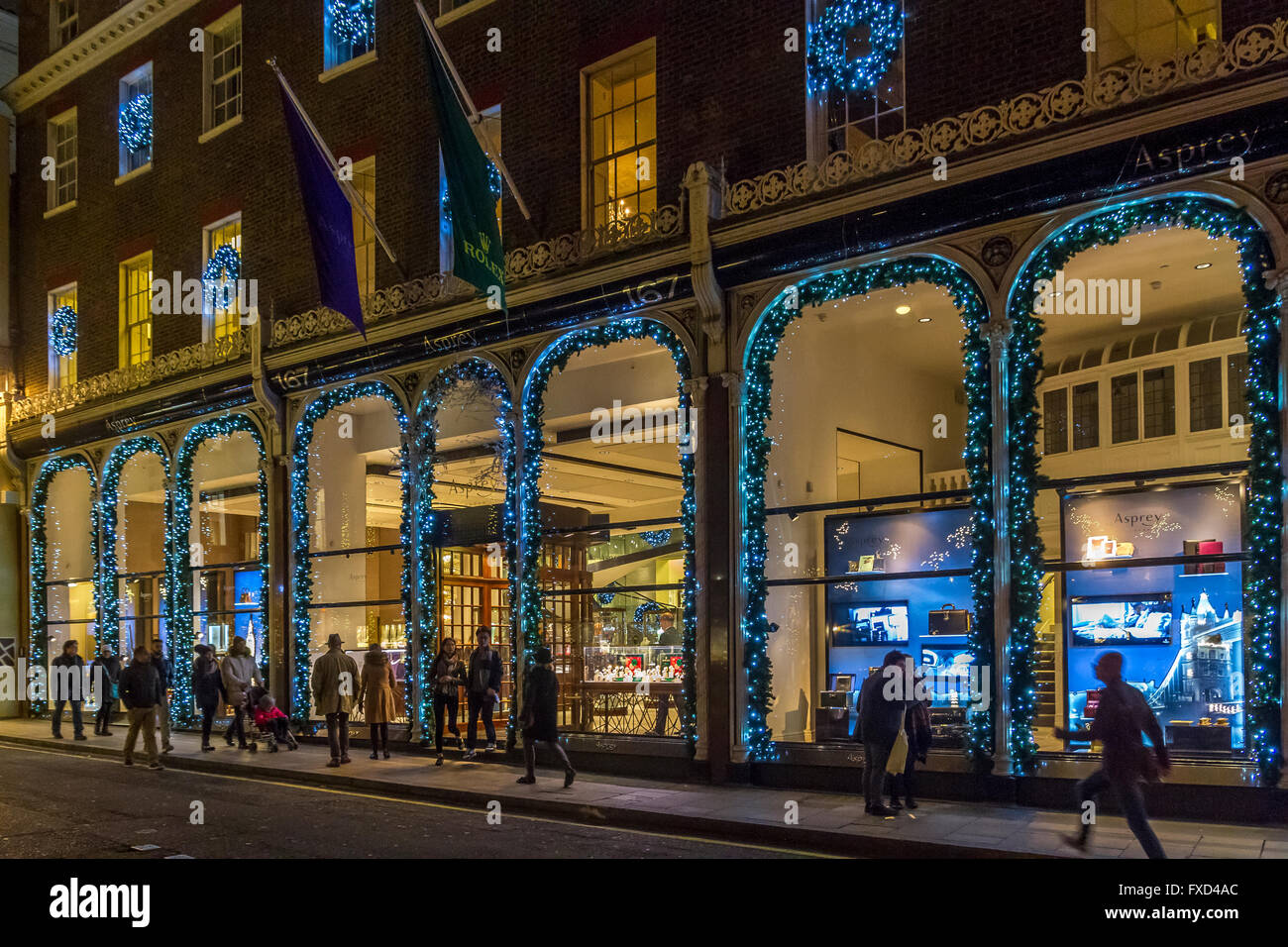 Christmas Shopper oltrepassando il lusso iconica gioiellerie Asprey situato su Bond St nel tempo di Natale a Londra Foto Stock
