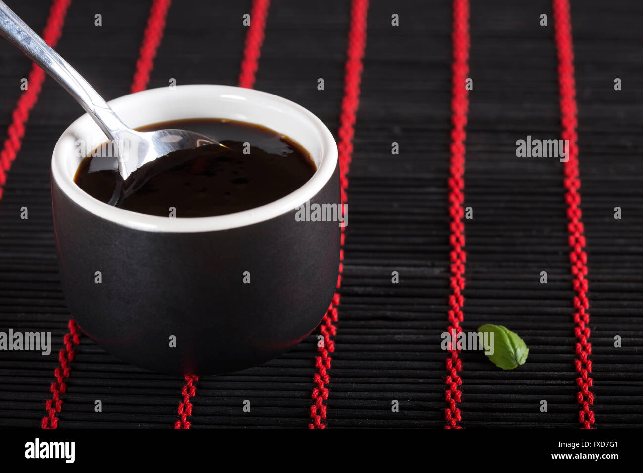 Ciotola di salsa di soia su black bamboo rug Foto Stock