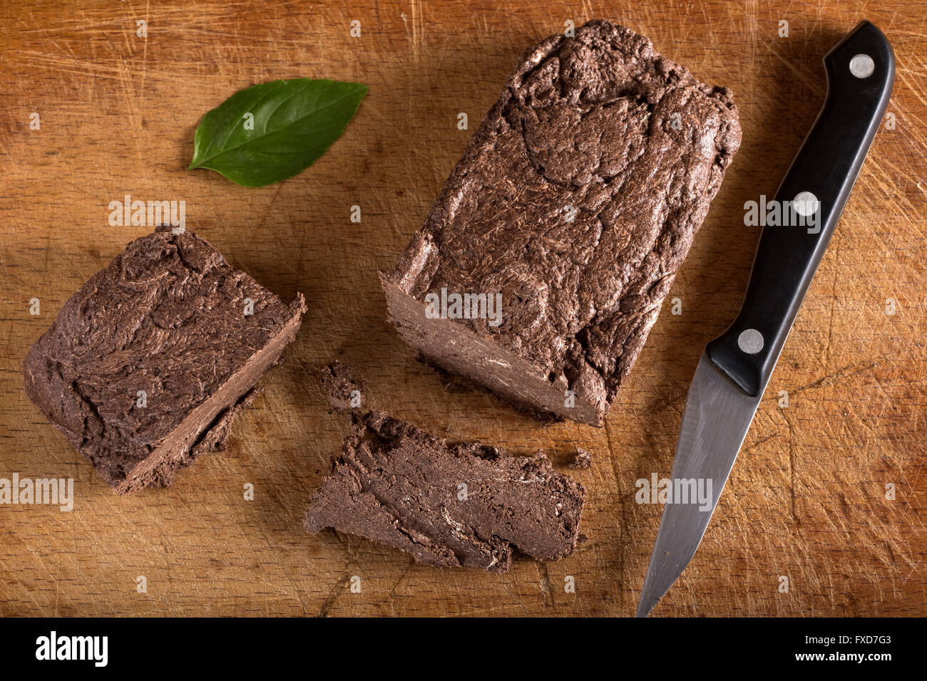 Pezzo di cioccolato halvah su sfondo di legno con coltello da cucina Foto Stock