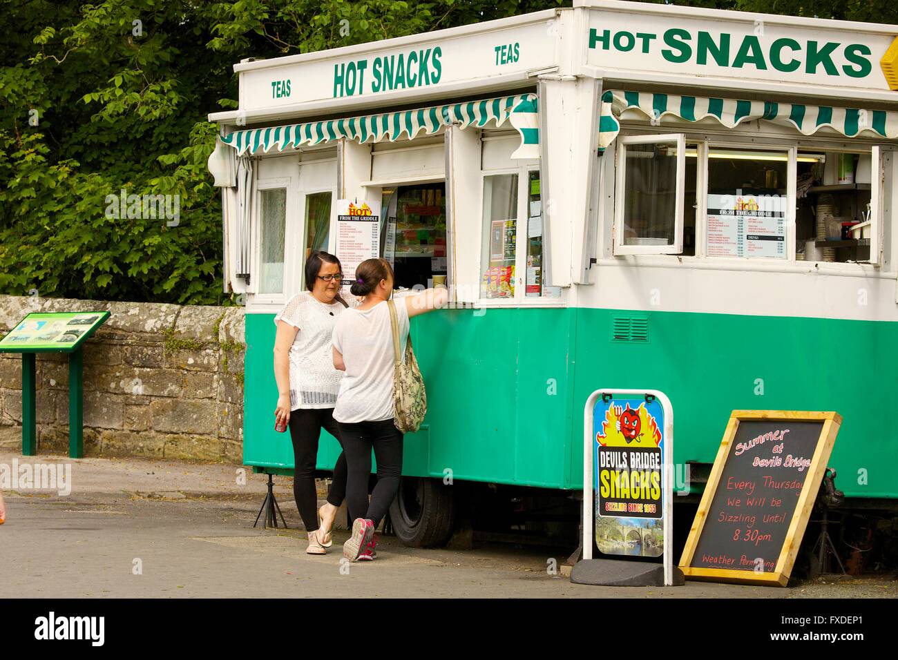 Due donne acquistare spuntini. Devils Bridge spuntini van, Ponte del Diavolo, Kirkby Lonsdale, South Lakeland, Cumbria, Inghilterra, Regno Unito. Foto Stock