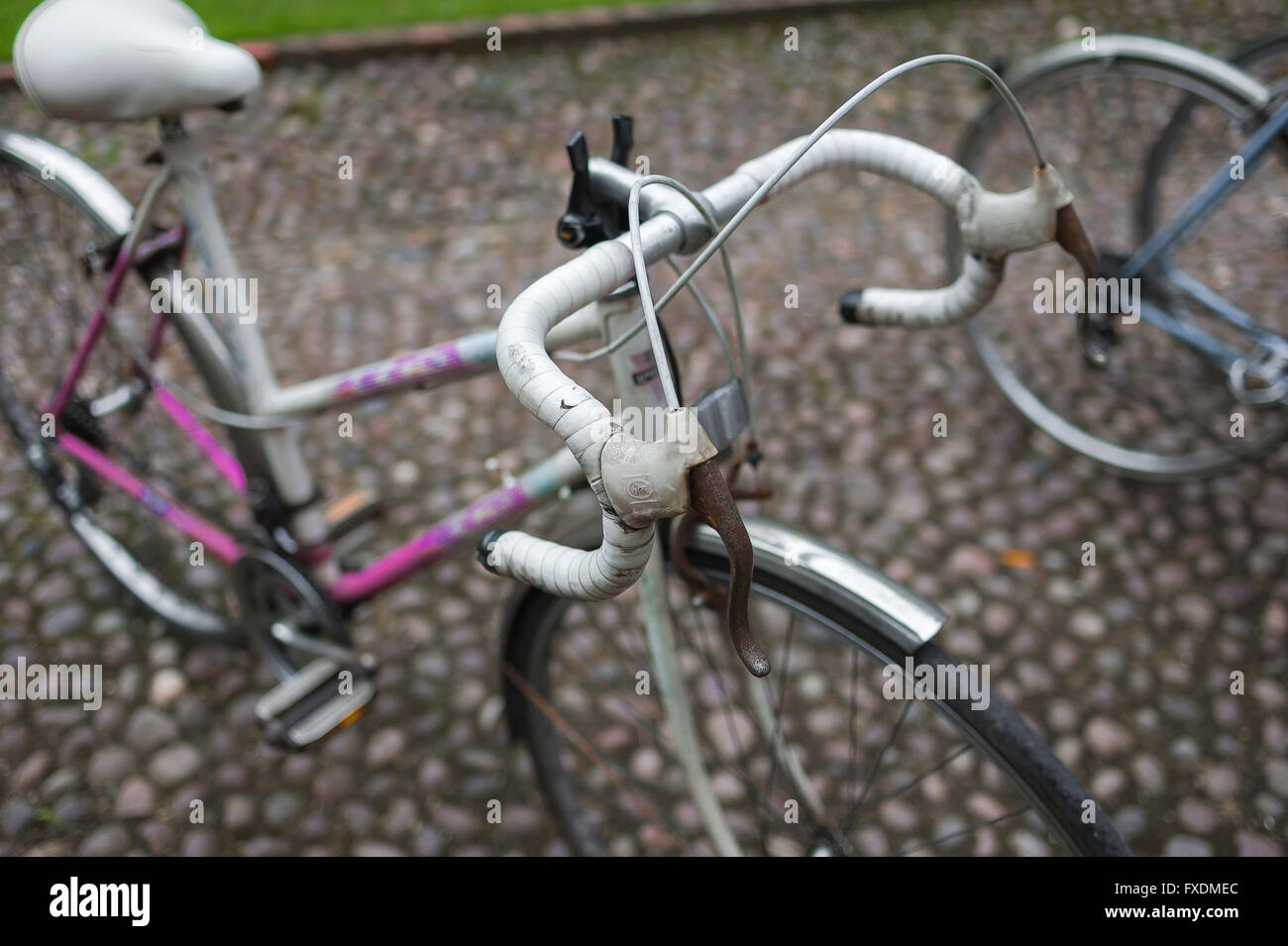 Bicicletta, vista su una bici da corsa di una donna parcheggiata su una strada acciottolata nel centro di Cambridge, Inghilterra, Regno Unito Foto Stock