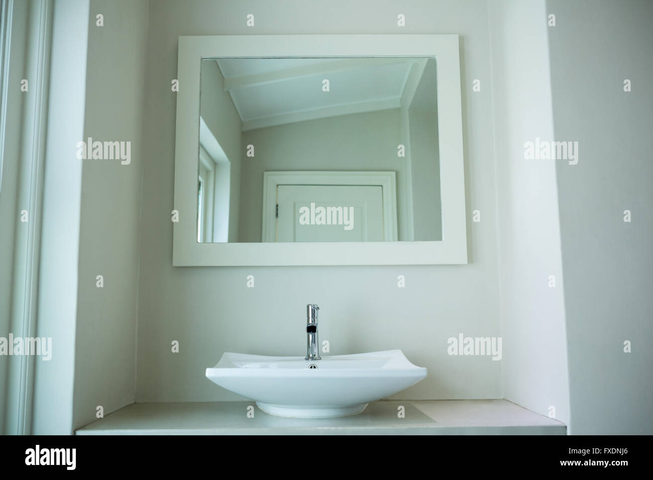 Dissipatore di bianco e uno specchio in bagno Foto Stock
