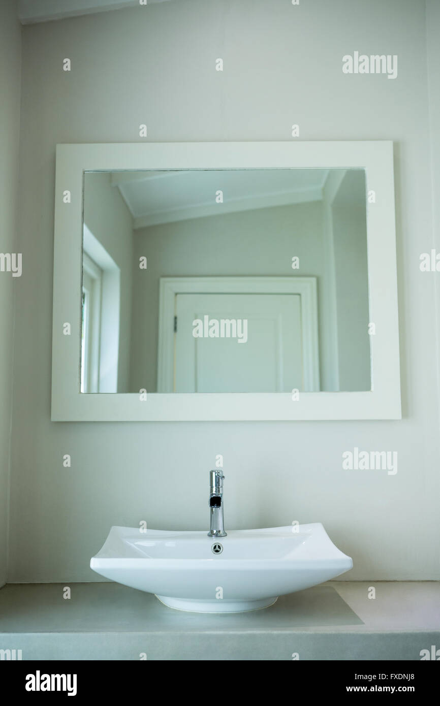 Dissipatore di bianco e uno specchio in bagno Foto Stock