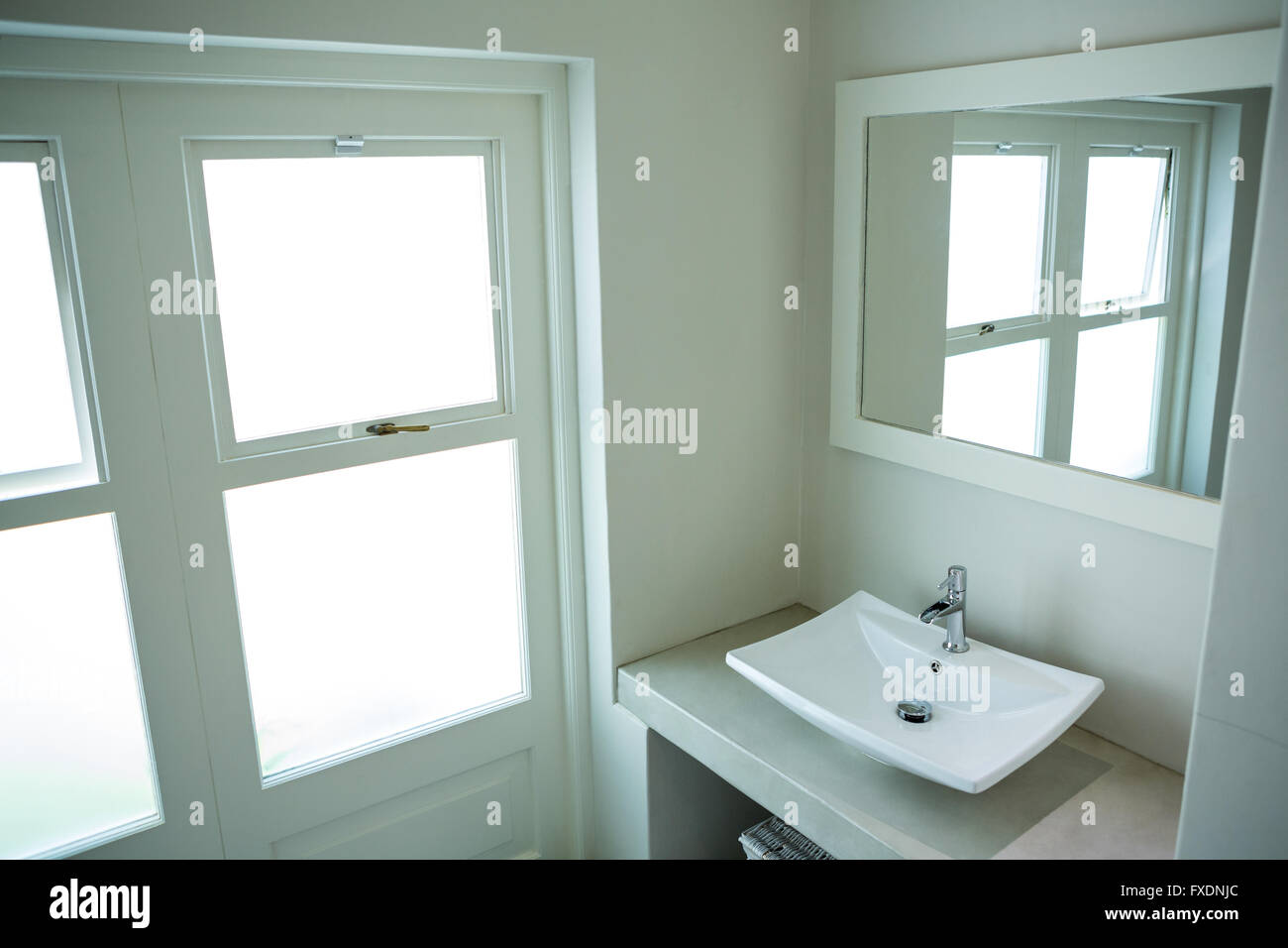 Dissipatore di bianco e uno specchio in bagno Foto Stock