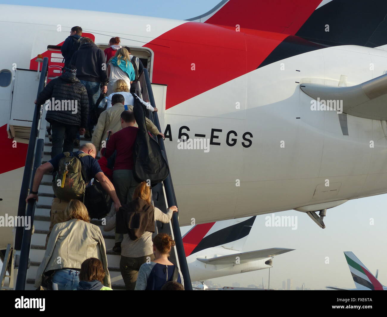 Passeggeri salendo le scale per salire a bordo del volo Emirates Foto Stock