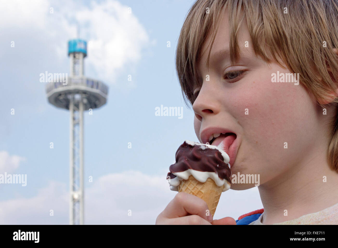 Ragazzo a mangiare il gelato nella parte anteriore del City Skyliner, fiera del divertimento 'Dom', Amburgo, Germania Foto Stock