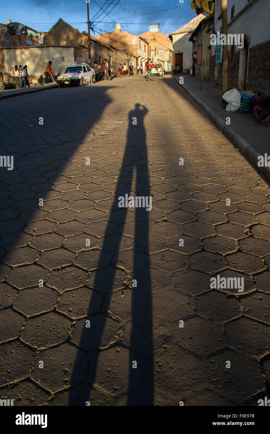 Bolivia, riflettendo l'ombra del fotografo su strada nella città. Foto Stock