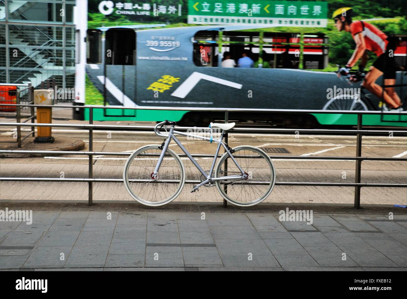 Parcheggiato il colore bianco per biciclette e un bus in movimento sullo sfondo con una foto di un ciclista. Foto Stock