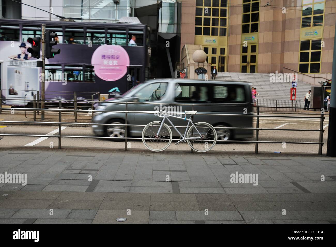 Parcheggio biciclette Bianchi e un bus in movimento in background. Foto Stock