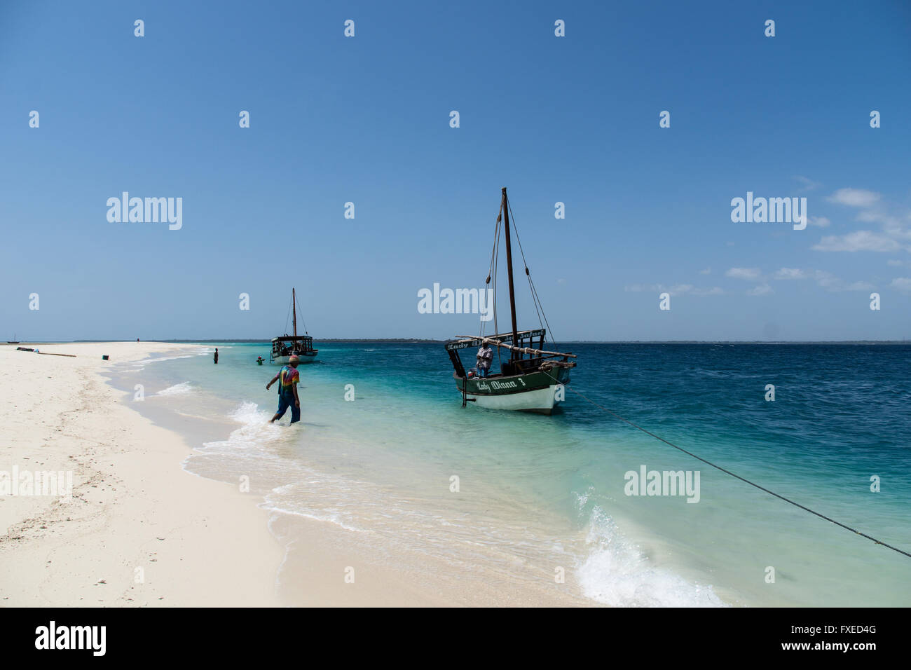 Barca Privata le guide di giro lavorando fuori la spiaggia sabbiosa nell'Oceano Indiano, Tanzania Foto Stock