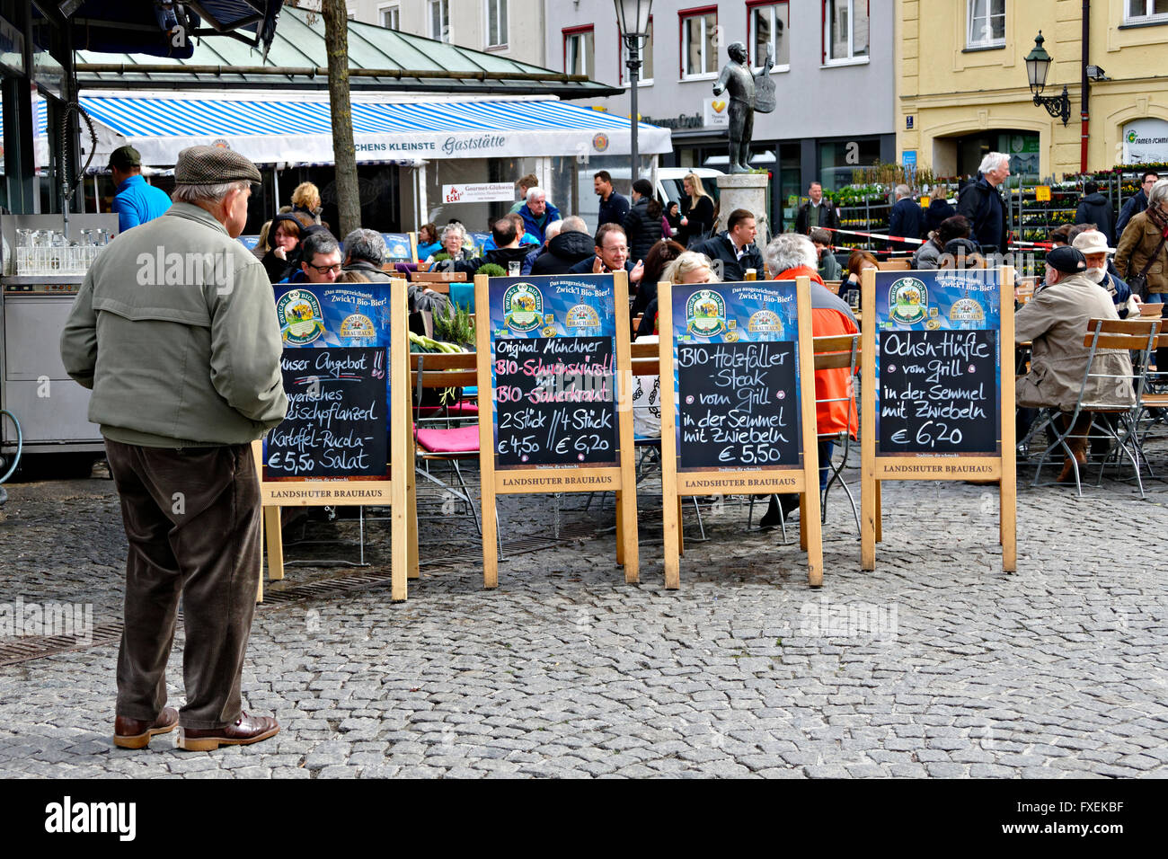 Uomo anziano studiando la birra bavarese cibo giardino schede di menu al Viktualienmarkt (mercato Viktualien), Monaco di Baviera, Baviera, Germania Foto Stock