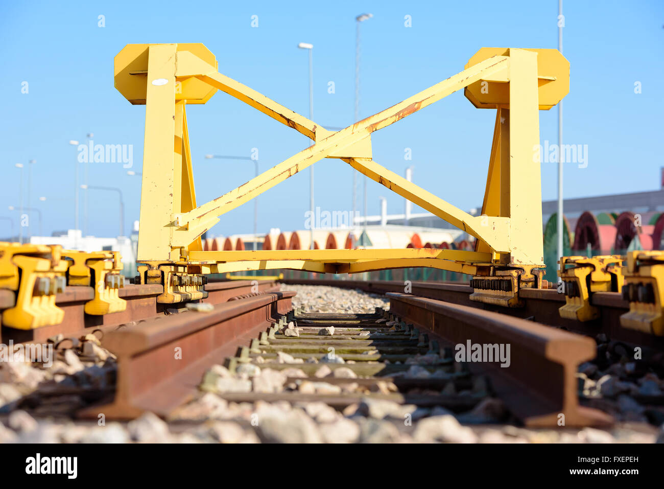 Di colore giallo brillante Treno fermata tampone paraurti o alla fine di un binario ferroviario. Foto Stock