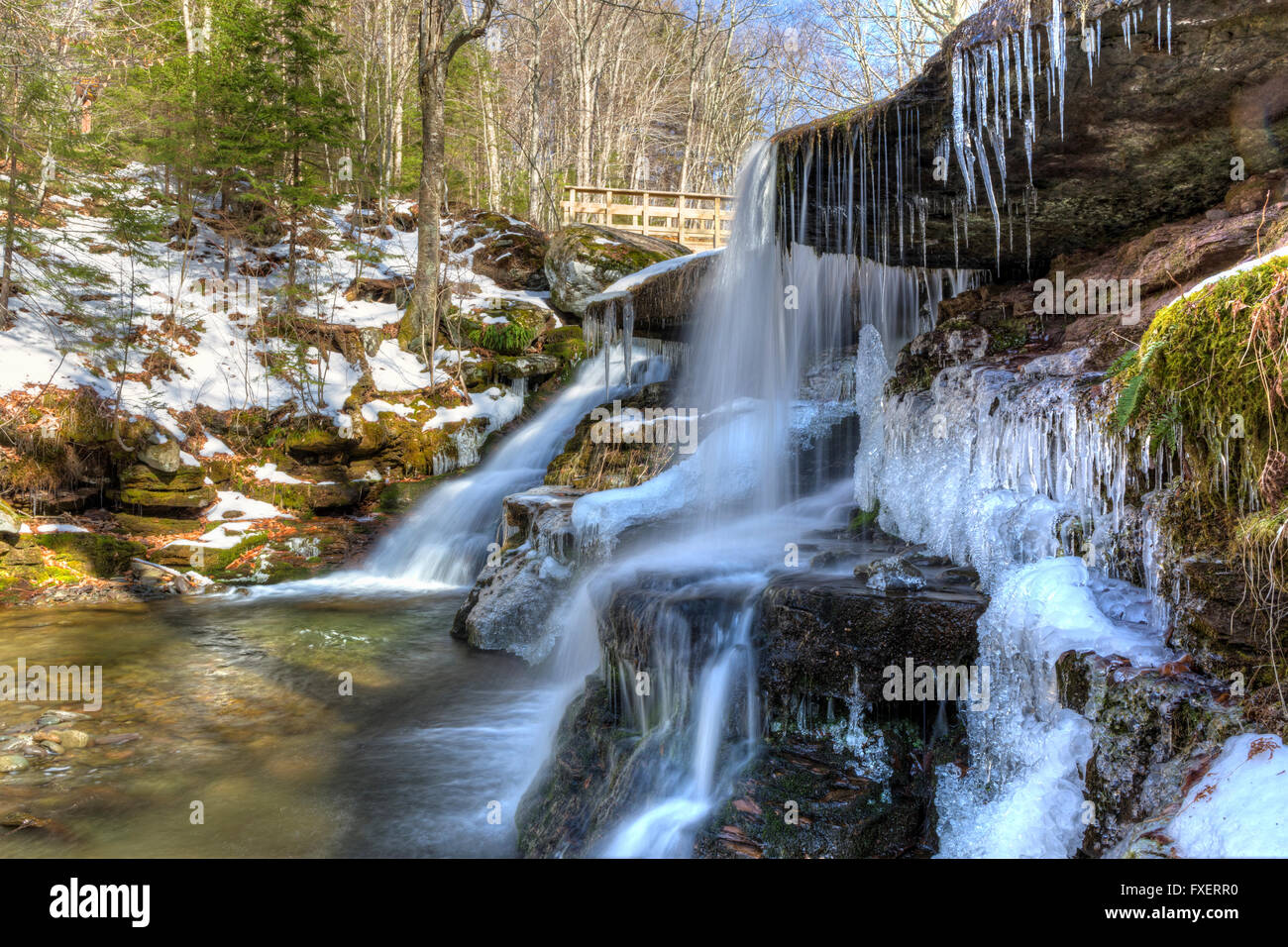 L'acqua scende dolcemente su strati rocciosi a parzialmente congelati West Kill cade nelle Catskills Mountains montagne di New York. Foto Stock