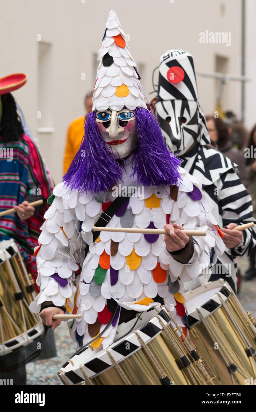 Chiudere la vista su un gruppo di Carnevale di Basilea i partecipanti in diversi costumi, giocando sul dipinto di golden rullante Foto Stock