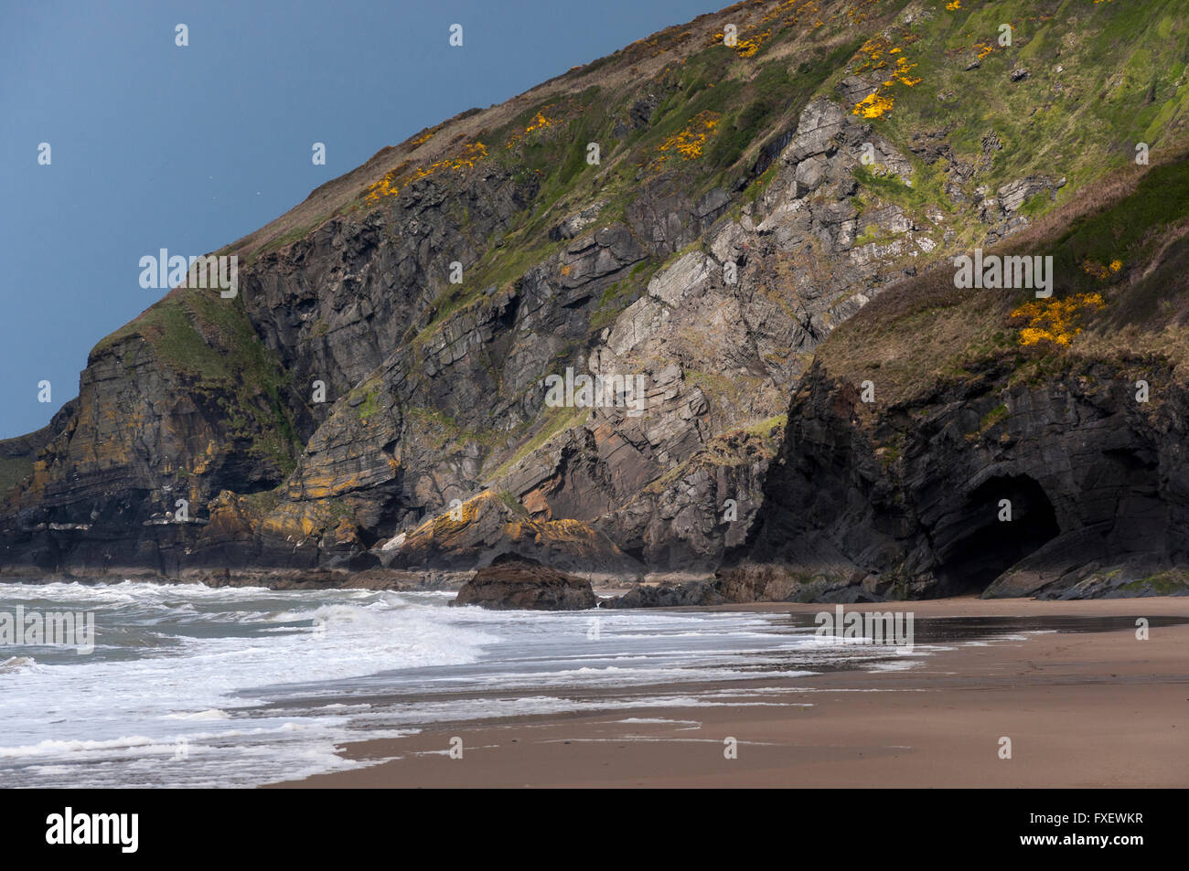 Alte scogliere in Penbryn beach nel Galles occidentale. Foto Stock