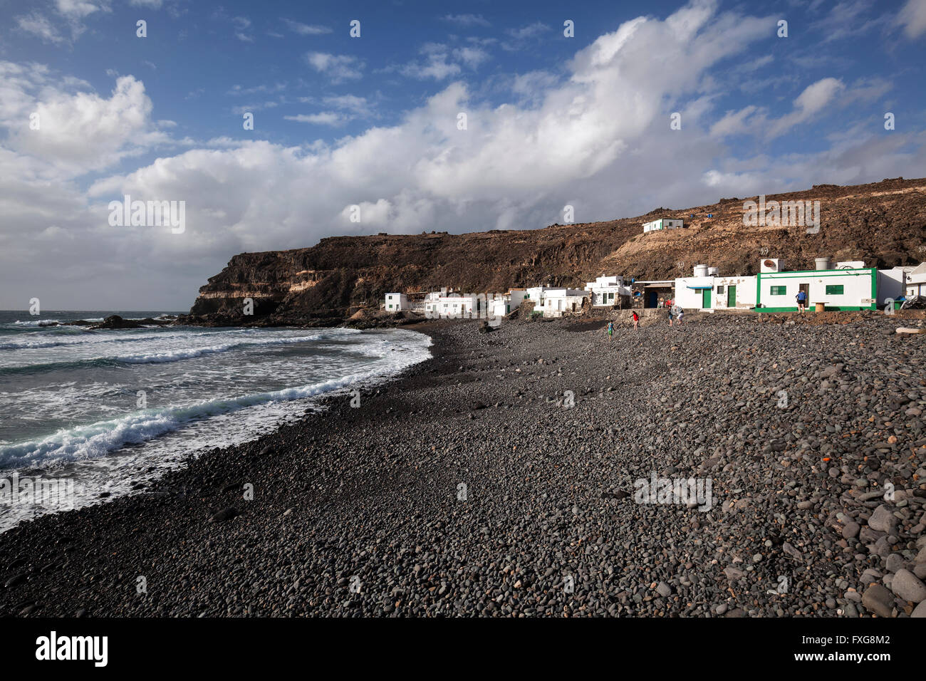 Rocce laviche sulla spiaggia di lava, Los Molinos villaggio di pescatori dal mare, Fuerteventura, Isole Canarie, Spagna Foto Stock