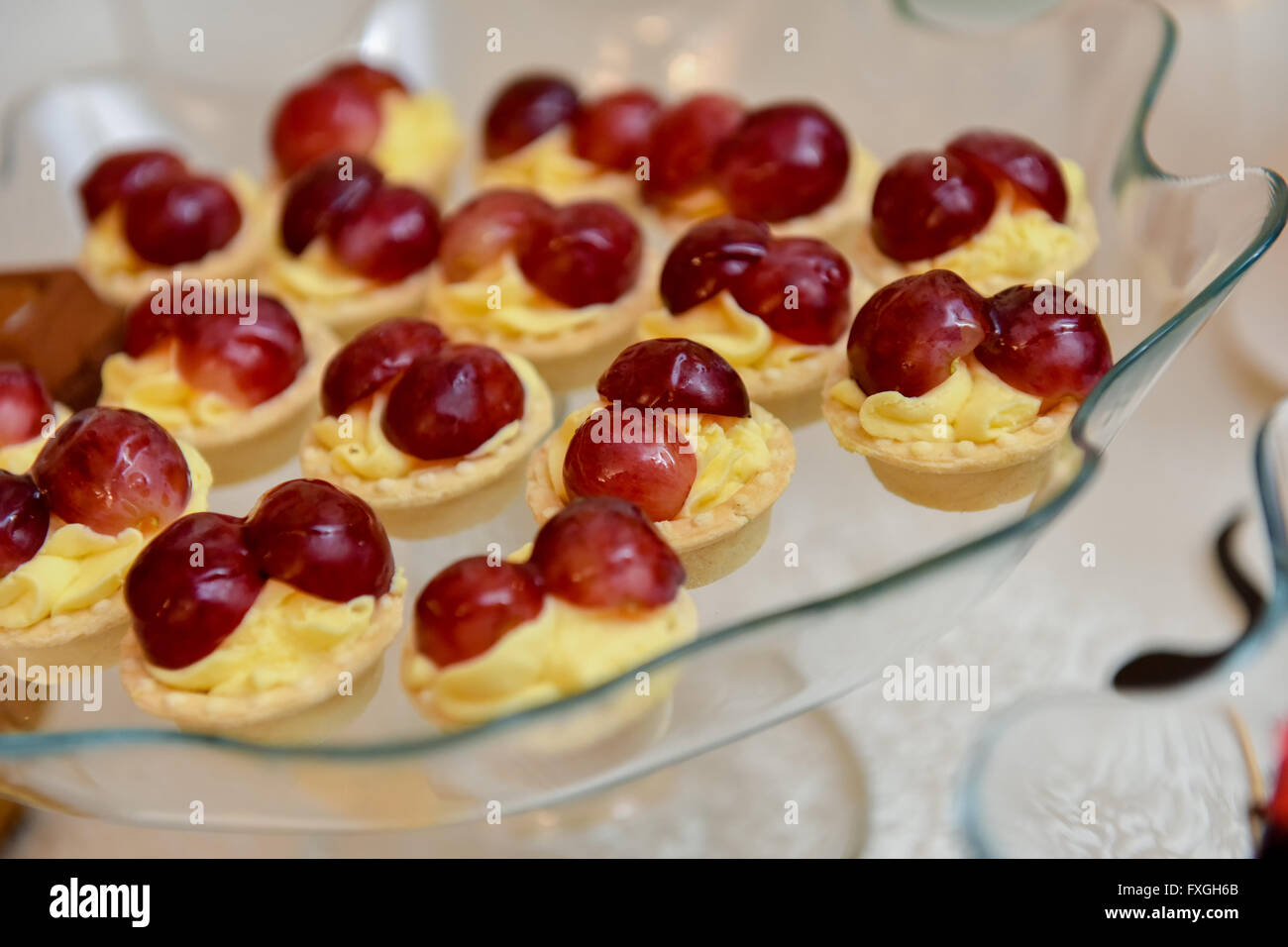 Tortine con vaniglia e uva sulla parte superiore Foto Stock