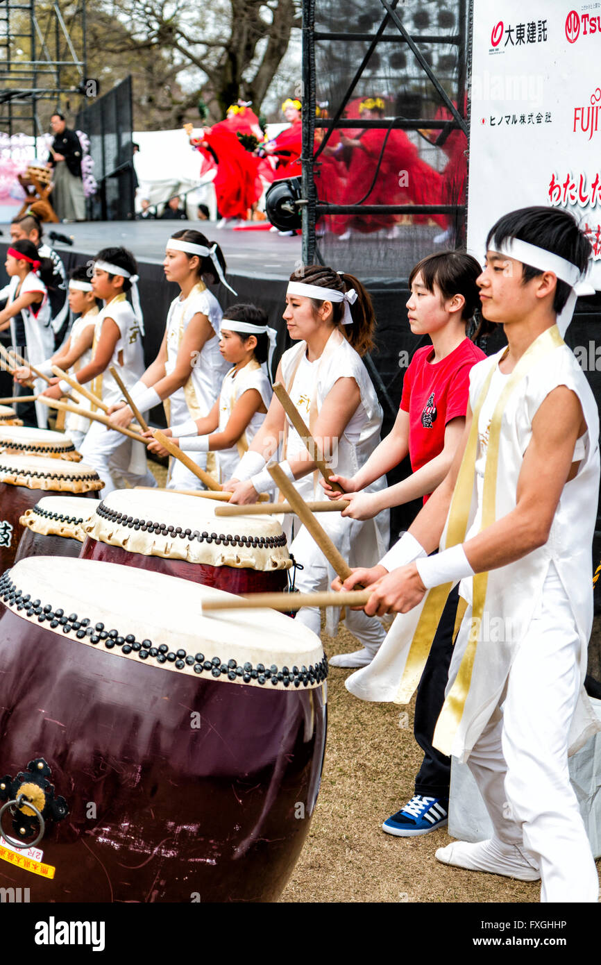 Taiko batteristi, Kumi-daiko concerto. Vista laterale della fila di bambini e adolescenti in tradizionale costume drumming, battendo la linea di nagado-daiko tamburi. Foto Stock