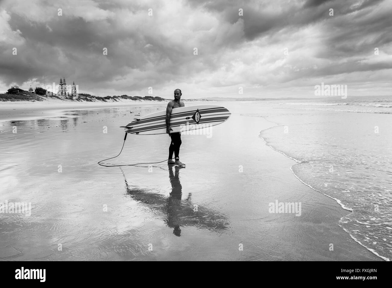 Un giovane uomo passa il surf, waipu cove, waipu, northland e Nuova Zelanda Foto Stock