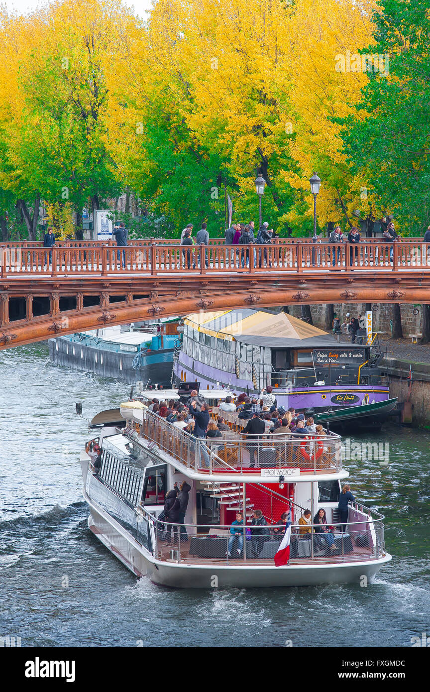 Parigi autunno ponte, vista in autunno di una barca turistica Senna (bateaux) che si avvicina il ponte in legno du Double a Parigi, Francia. Foto Stock