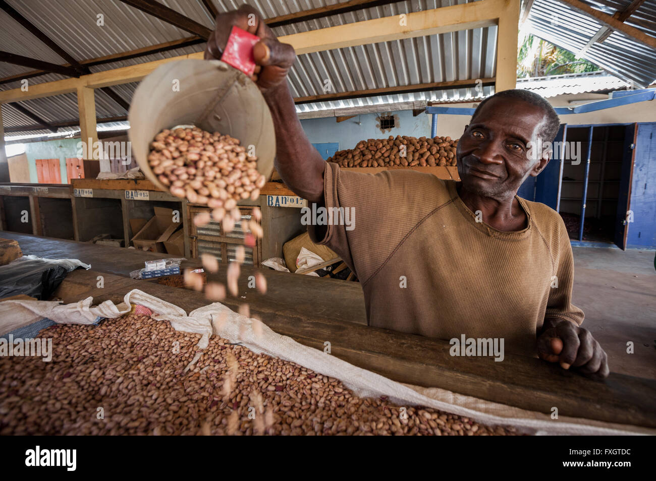 Mozambico, Africa, un uomo di fagiolo di vendita presso il mercato nella città. Foto Stock