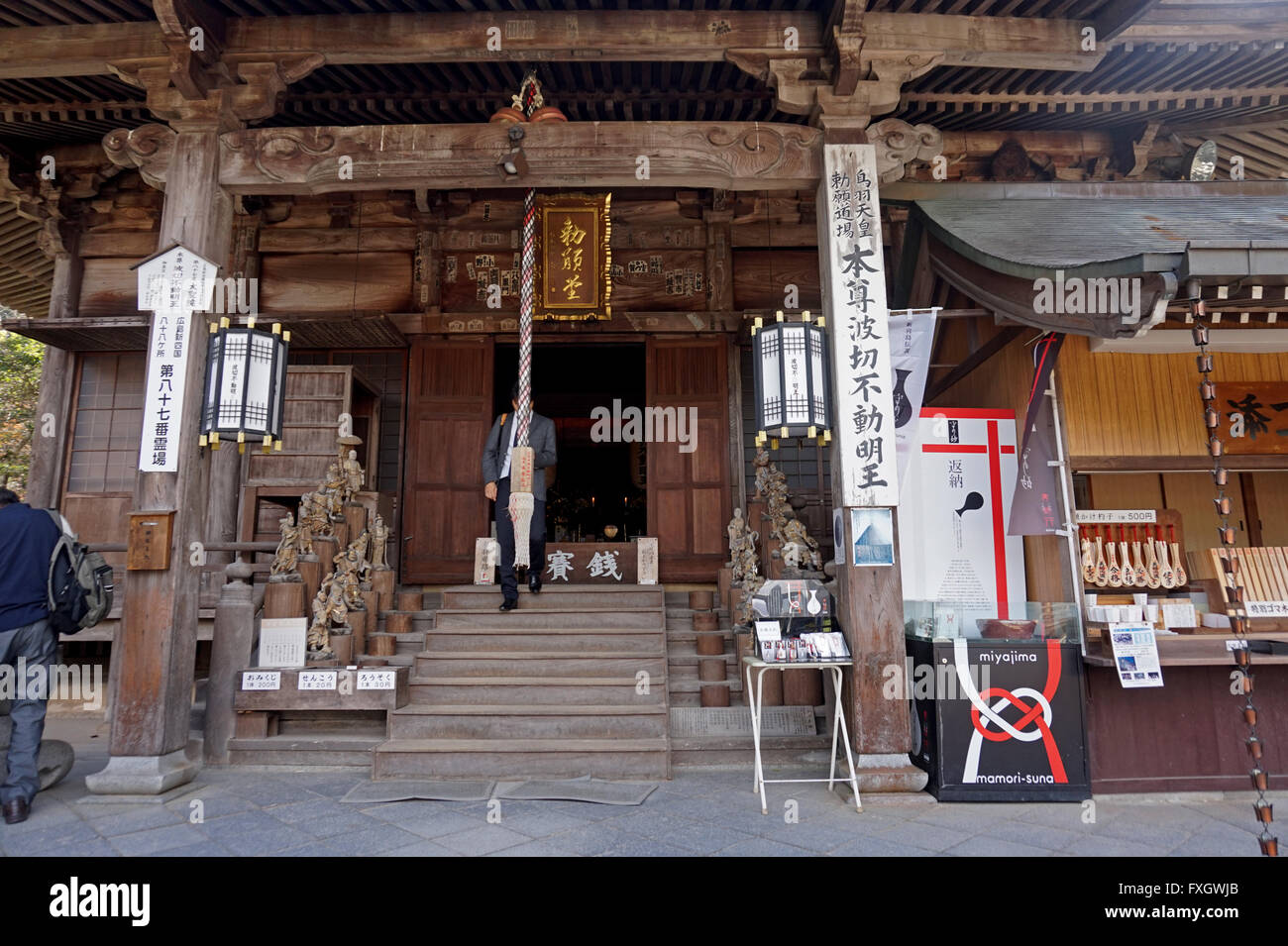 Le persone che visitano una hall di Daisho-nel tempio, l'isola di Miyajima, Prefettura di Hiroshima, Giappone Foto Stock