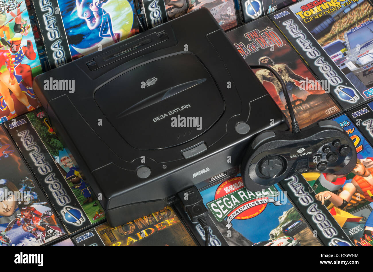 Una PAL Sega Saturn console con un controller standard su un letto dei suoi migliori giochi. Foto Stock