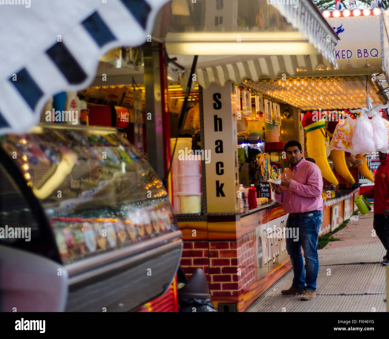 Un uomo acquista rinfreschi a uno snack kiosk presso un parco di divertimenti. Foto Stock