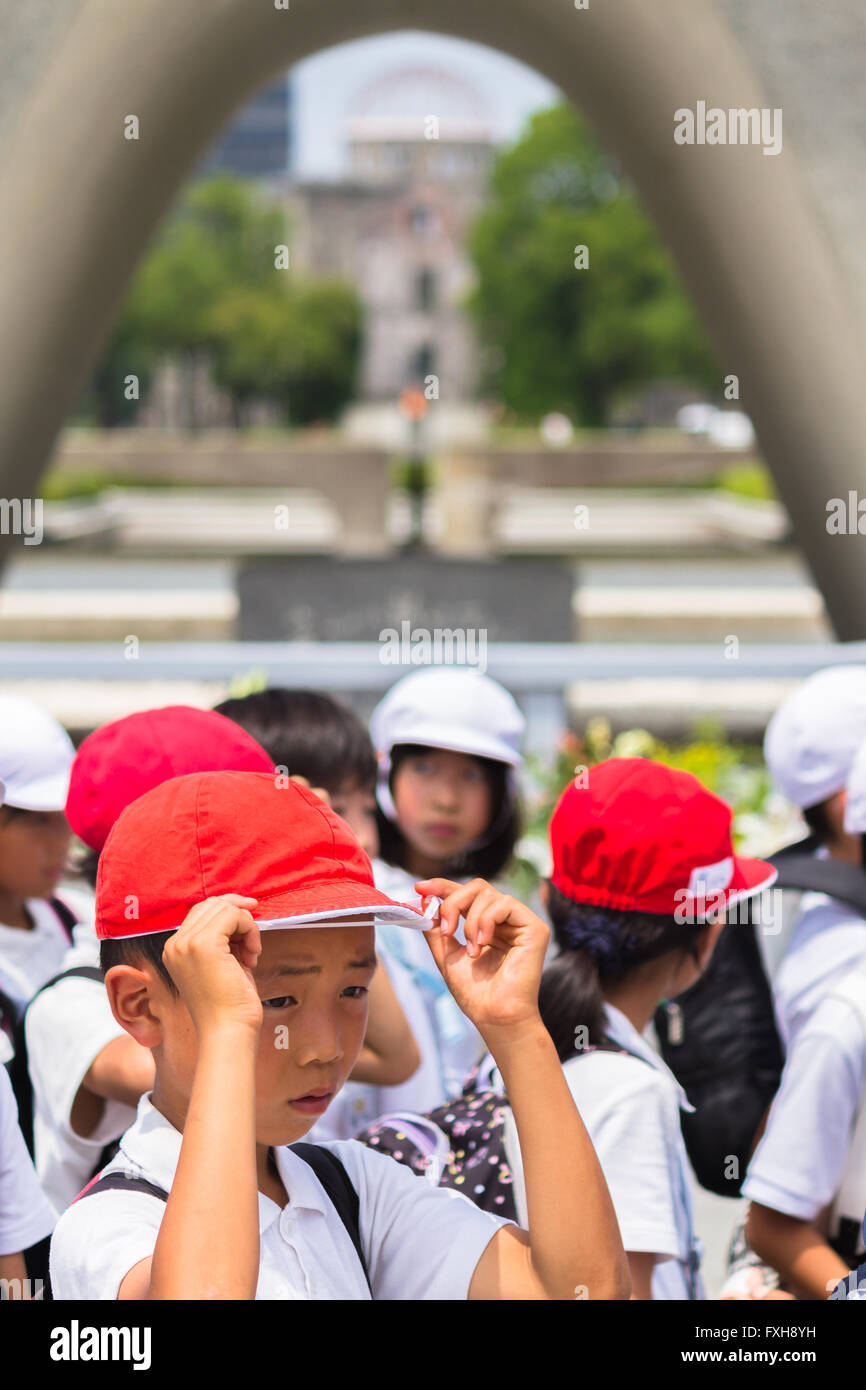 Scuola Giapponese bambini visita il Memorial il Cenotafio nel centro di Hiroshima Peace Memorial Park Foto Stock