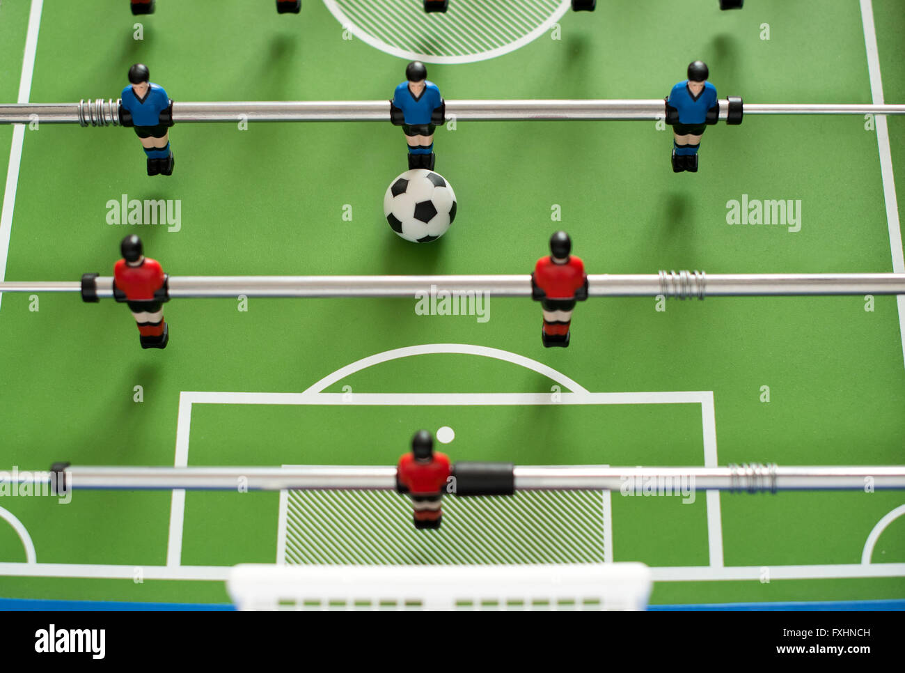 La prospettiva in prima persona vista verso il basso su una metà di foosball impostato con un piccolo pallone da calcio Foto Stock