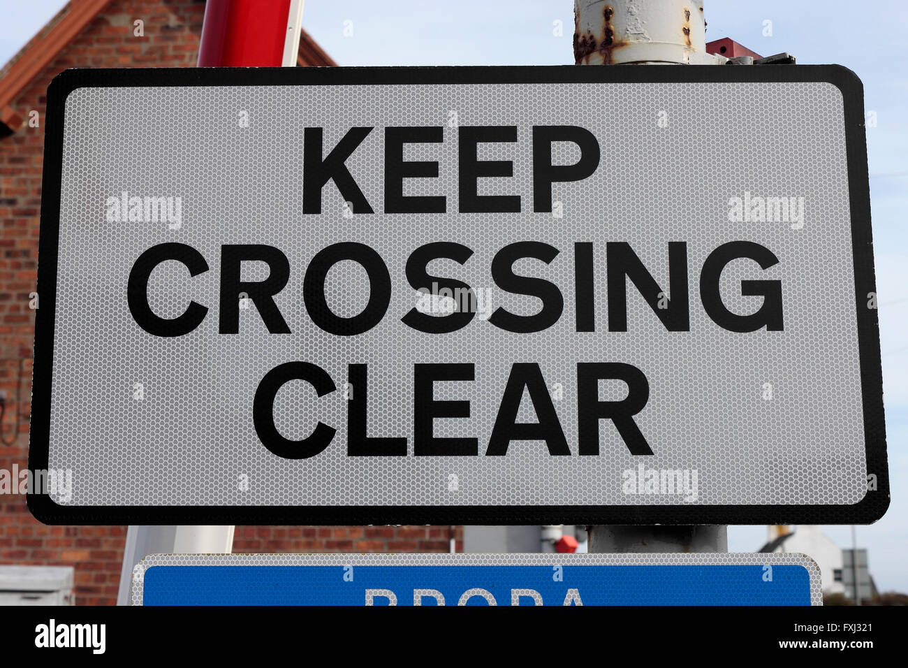 Un passaggio a livello 'Continuare attraversando chiaro segno in Brora Scozia, Regno Unito Foto Stock