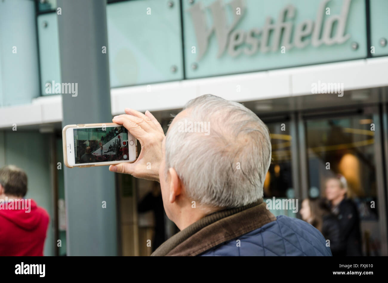 Un uomo prende una foto con il suo smartphone. Foto Stock