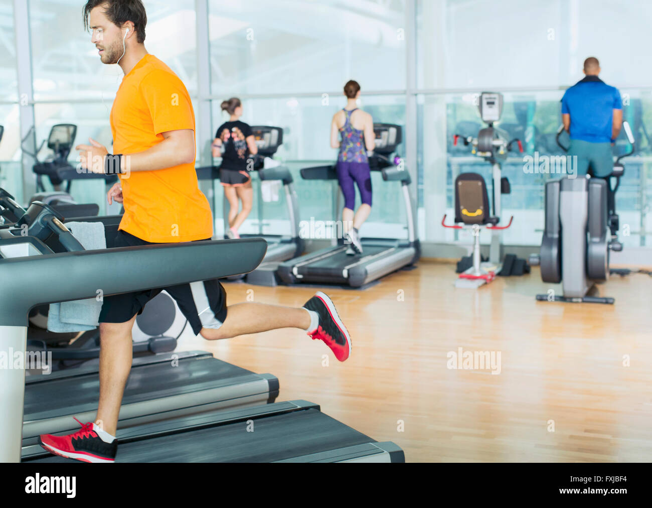 Uomo che corre sul tapis roulant in palestra Foto Stock