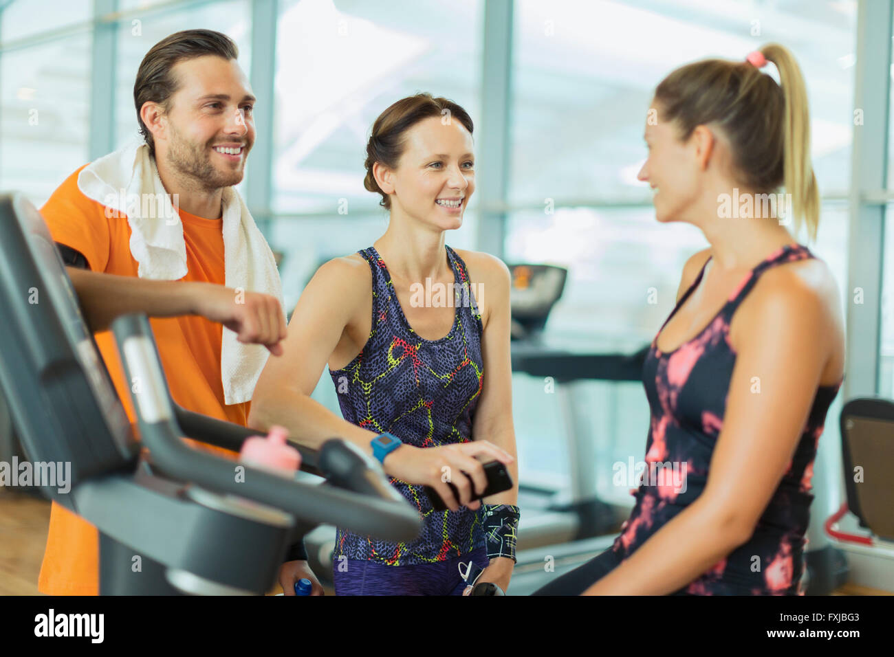 Sorridente amici parlando in palestra Foto Stock