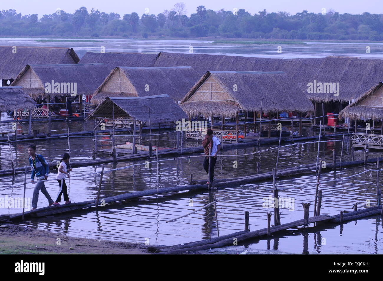 Cambogiani negoziano con cura un pericoloso passaggio pedonale in legno sulla riva del lago, Tonle Bati, provincia di Takéo, Cambogia. Credito: Kraig Lieb Foto Stock